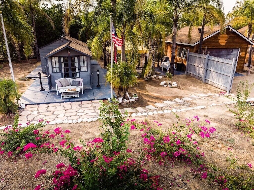 A residential property with a patio, a small house, and a garage.
