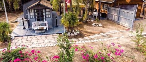A residential property with a patio, a small house, and a garage.