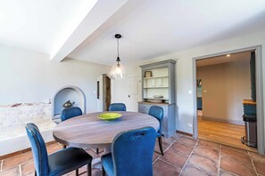 A dining area with a round table, chairs, and a hanging light fixture. - Mill near Carcassonne, with a pool and river (Bouilhonnac)