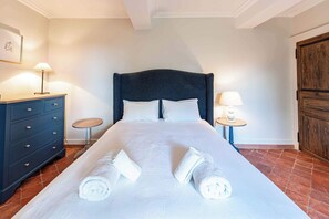 Habitación de hotel con una cama grande, dos mesitas de noche, un aparador y un armario.