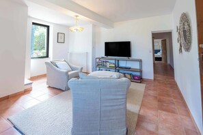 A living room with a sofa, a television, and a bookshelf. - Mill near Carcassonne, with a pool and river (Bouilhonnac)