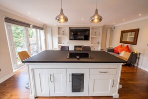 A modern kitchen with a central island, built-in appliances, and pendant lighting. - Top-Floor 3-Bed Flat Sleeps 6 · Free Parking · Walk to Clissold Park (Greater London)