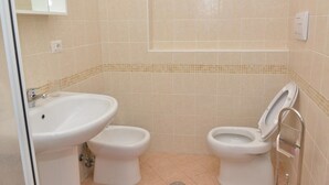 A bathroom with two toilets, a sink, and a shower area. - Apartment 'Rietinn - Loggia Del Vignola' with Wi-Fi (Rieti)