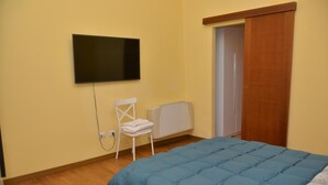 A bedroom with a bed, a chair, a radiator, and a television on the wall. - Apartment 'Rietinn - Loggia Del Vignola' with Wi-Fi (Rieti)