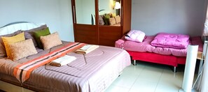 Un dormitorio con una cama, una mesita de noche, un espejo y un armario.