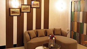 Una sala de estar moderna con un sofá modular, una mesa de centro de vidrio y un jarrón decorativo.