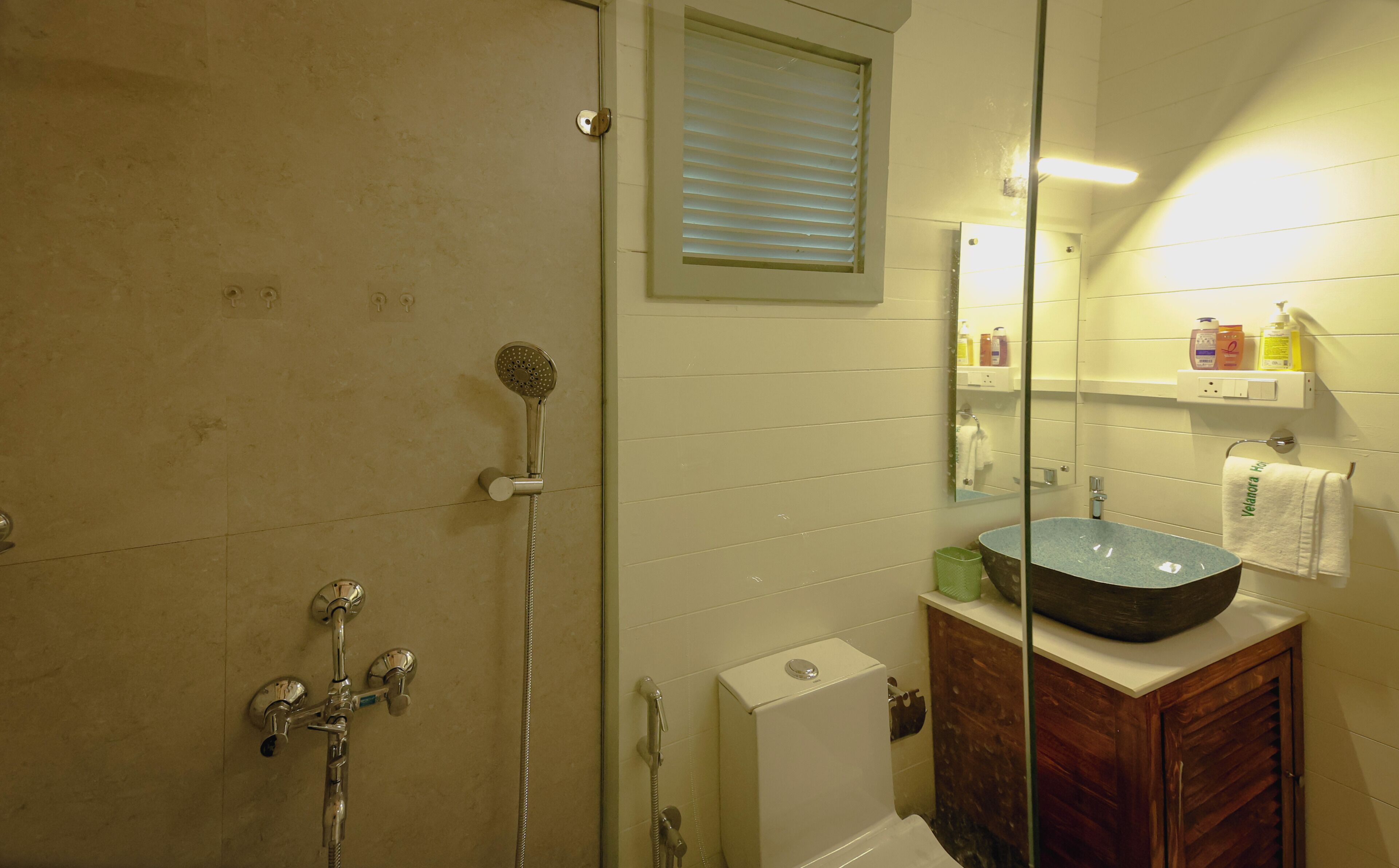 A bathroom with a shower, a sink, and a mirror.