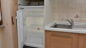 Una cucina con frigorifero integrato, lavandino e pensili in legno.