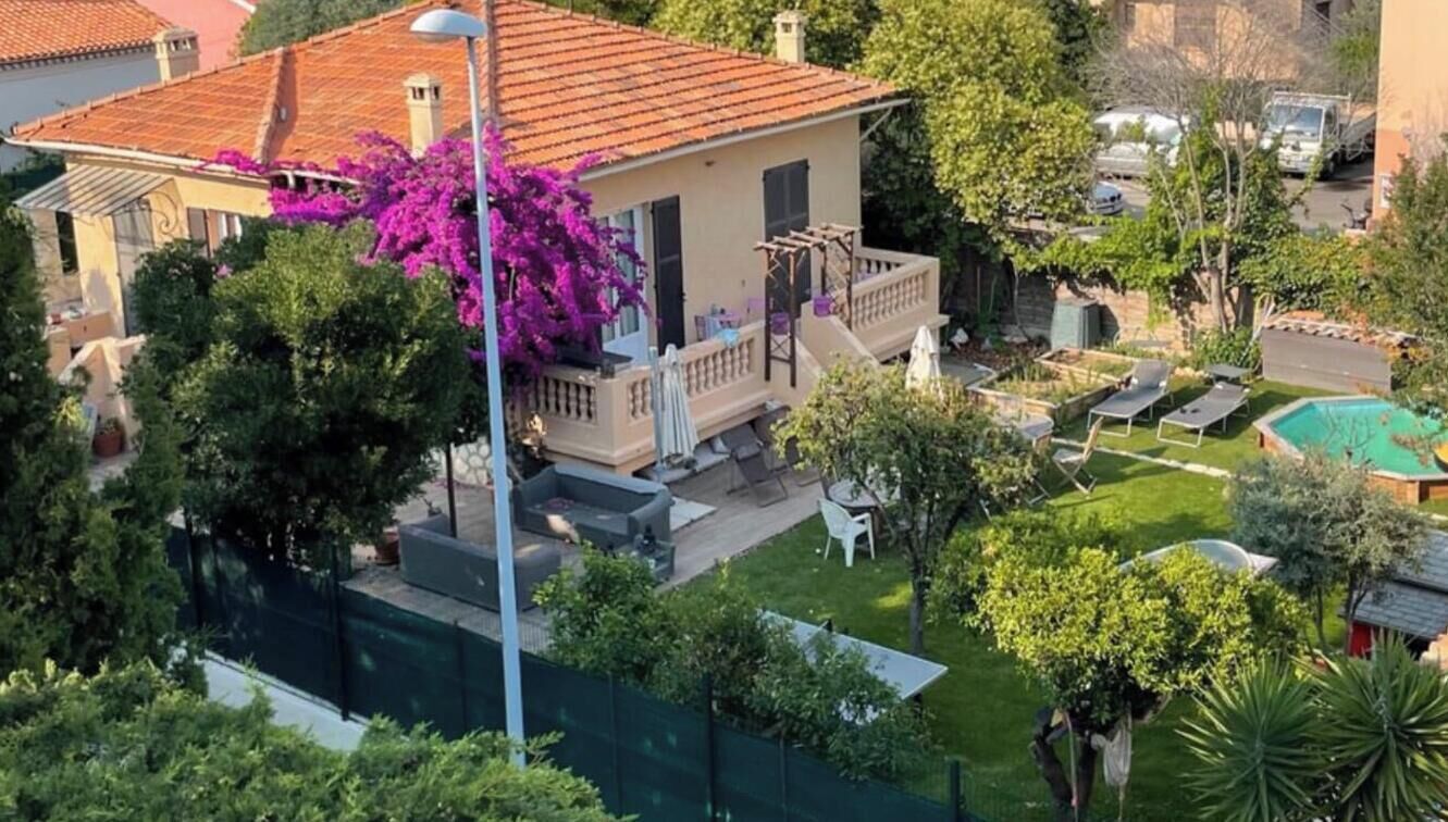 A residential property with a swimming pool, outdoor seating, and a garden.