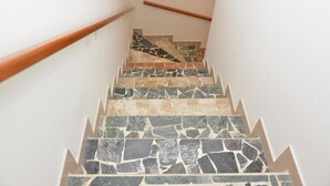 Un escalier avec une rampe en bois et des marches en pierre.