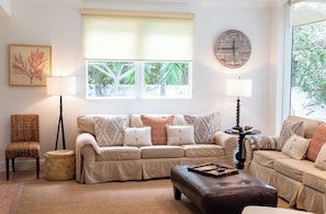 A living room with a beige sectional sofa, two side chairs, a coffee table, and a fireplace. - BREATHTAKING : on water front with panoramic views + pool + dock (Dunmore Town)