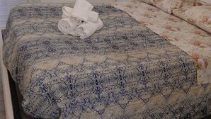 Une chambre à coucher avec un lit, un luminaire suspendu et une armoire.