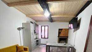 A compact living space with a sofa, a dining table, and a kitchen area.