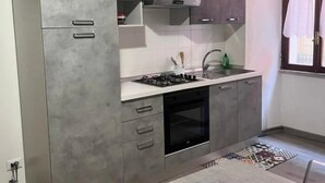 A compact kitchen with a built-in oven, a stove, and a sink.