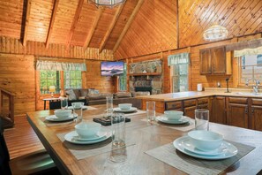 L’intérieur d’une cabane en bois comprend un coin repas, une cuisine et un espace de vie.