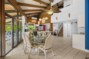A modern kitchen with a glass dining area, wooden ceiling beams, and a ceiling fan. - Mauna Kai 7B by Gather | Princeville 3BR + Loft Condo w/ Shared Pool (Princeville)