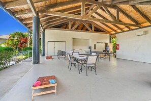 An outdoor covered patio with a dining area, chairs, and a table. - Mauna Kai 7B by Gather | Princeville 3BR + Loft Condo w/ Shared Pool (Princeville)