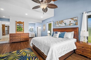 A bedroom with a large bed, wooden headboard, and a ceiling fan. - Mauna Kai 7B by Gather | Princeville 3BR + Loft Condo w/ Shared Pool (Princeville)