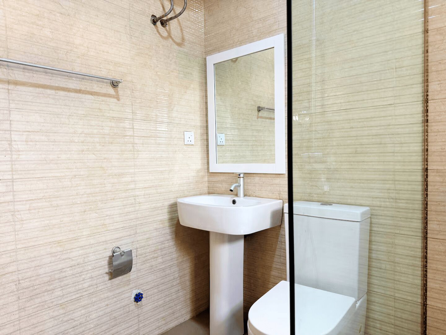 A bathroom with a white sink, a mirror, and a toilet.