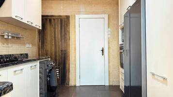 Een moderne keuken met een inbouwoven, een wasmachine en een koelkast.