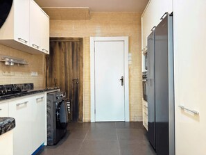 Een moderne keuken met een inbouwoven, een wasmachine en een koelkast.
