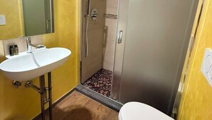 A bathroom with a white sink, toilet, and a shower area with a glass door. - La Rocca Guest House & SPA - Standard Room 1 (Montefalco)