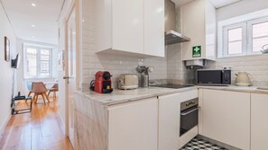 Eine moderne Küche mit weißen Schränken, einer Mikrowelle, einem Wasserkocher und einem Toaster.