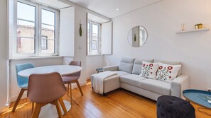 Ein stilvolles Wohnzimmer mit rundem Tisch, einer Couch und einem Couchtisch.