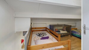 A compact room with a bunk bed, a small enclosed play area, and a radiator. - Villa Rosina with Private Terrace, Wi-Fi, and Air Conditioning (Gruissan)