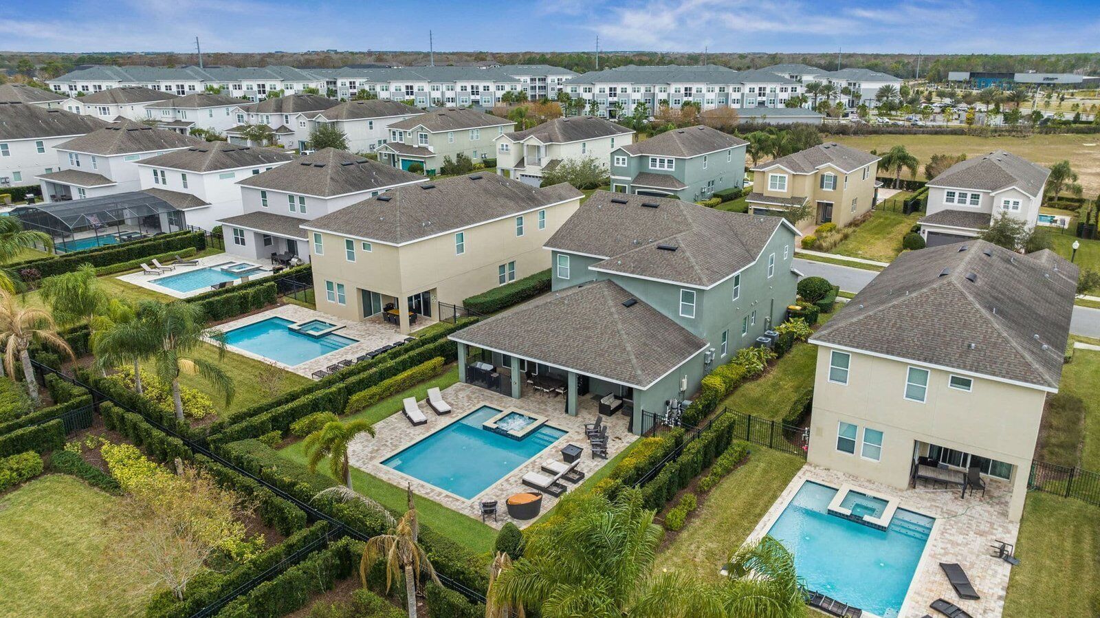 A residential area with multiple houses, each with a swimming pool and a covered patio area.