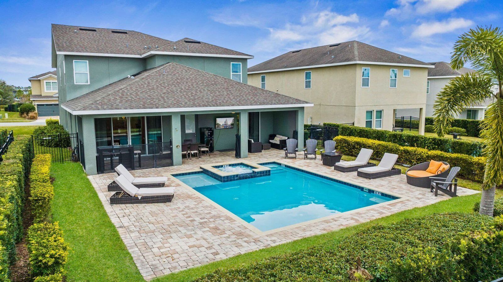 A residential property with a swimming pool, outdoor seating, and a well-maintained garden.