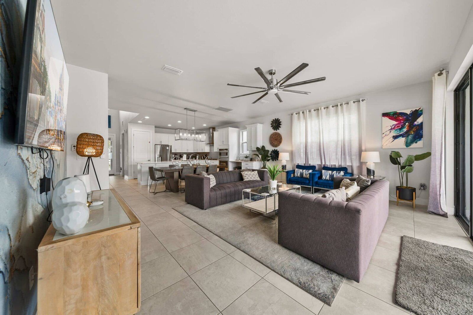 A modern living room with a sofa, coffee table, and a dining area with chairs.