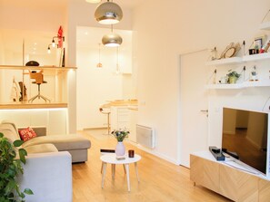 A modern living room with a sofa, coffee table, and a flat-screen TV. - Apartment with terrace and garden – sleeps 4 (Paris)