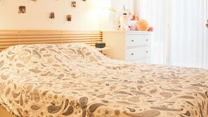 Ein Schlafzimmer mit einem Bett, einem Schminktisch, einem Spiegel und einer Wand mit Fotos.