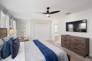 A bedroom with a bed, a dresser, a ceiling fan, and a flat-screen TV. - Harry Potter Games Room/Full resort facilties includeded/Private Pool and HotTub (Lake Buena Vista)
