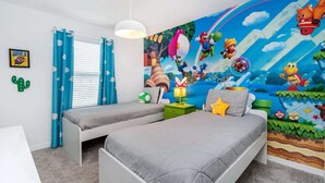 Et børneværelse med to senge, et muralmaleri, en kaktusdekoration og en Super Mario plakat.