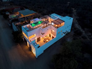 A modern multi-story building with a rooftop pool and outdoor seating area. - Villa Soho, your own boutique hotel in Cabo (Cabo San Lucas)
