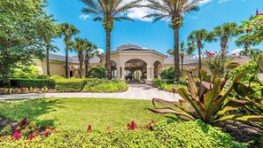 A hotel entrance with a covered walkway, palm trees, and well-maintained gardens. - Windsor Hill Resort/Private Pool/2 miles Disney /Short walk to Clubhouse & Pool (Kissimmee)