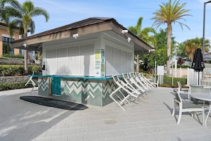 A small kiosk with a tiled floor, a counter with chairs, and a covered seating area. - Frozen Haven - Six Bedroom House, Sleeps 13 (Kissimmee)