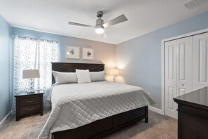 A bedroom with a bed, two bedside tables, a ceiling fan, and a door. - Linksview Villa - Eight Bedroom House, Sleeps 22 (Kissimmee)