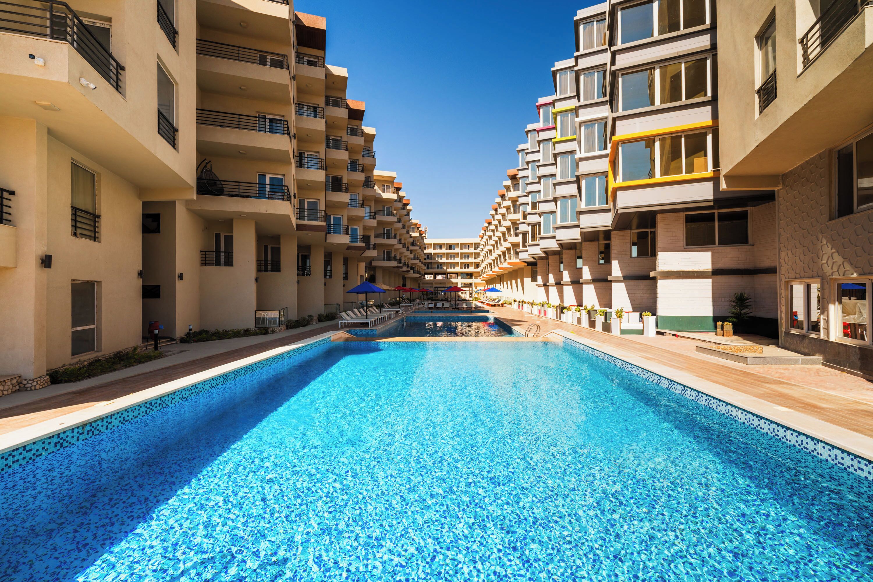 A swimming pool surrounded by multi-story residential buildings with balconies.