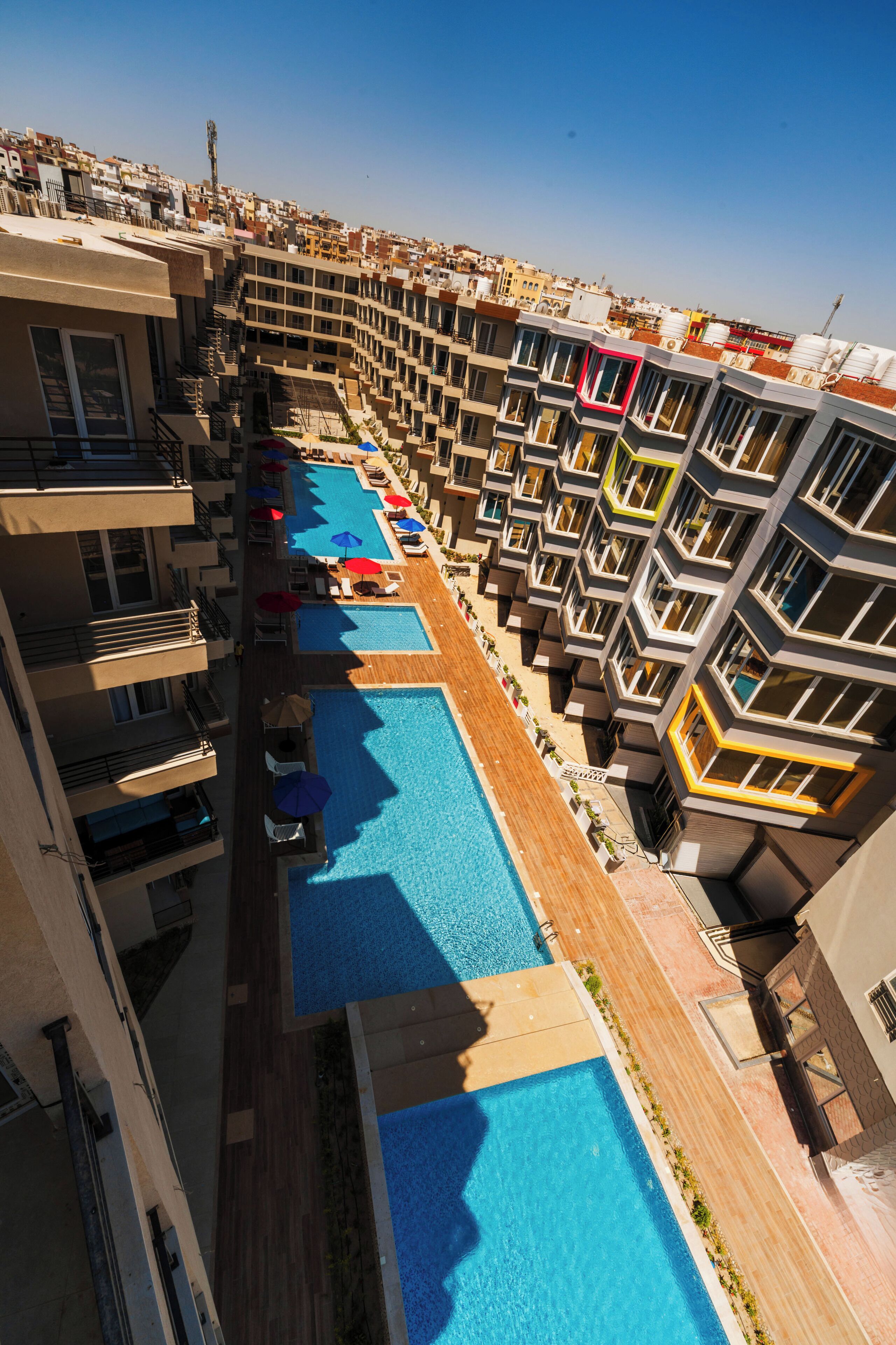 A multi-story hotel with a central swimming pool surrounded by balconies.