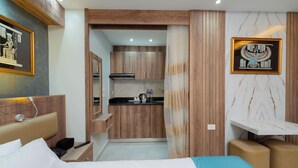 Ein Hotelzimmer mit Bett, Schreibtisch, Küchenzeile und Bad.