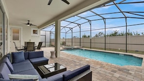 A covered outdoor area with a pool, seating, and a view of the sky. - Tropical Drift - Nine Bedroom House, Sleeps 22 (Kissimmee)