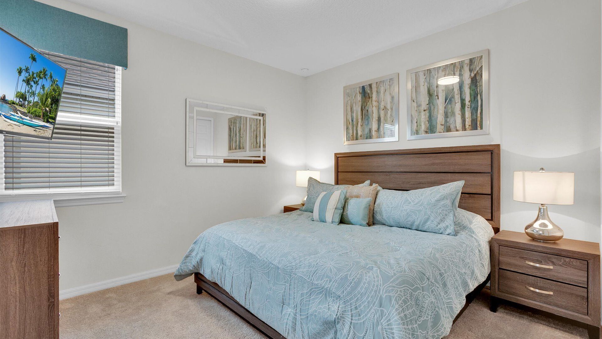 Une chambre à coucher avec un lit, des tables de chevet, une commode et des œuvres d’art accrochées aux murs.