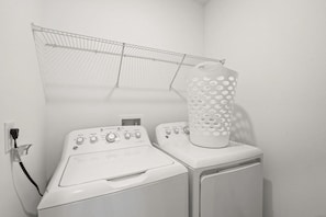 A laundry area with a washing machine and dryer, a drying rack, and a water heater. - The Splash Shot -Championsgate Resort, Amenities Included/Games Room/Free wifi (Kissimmee)
