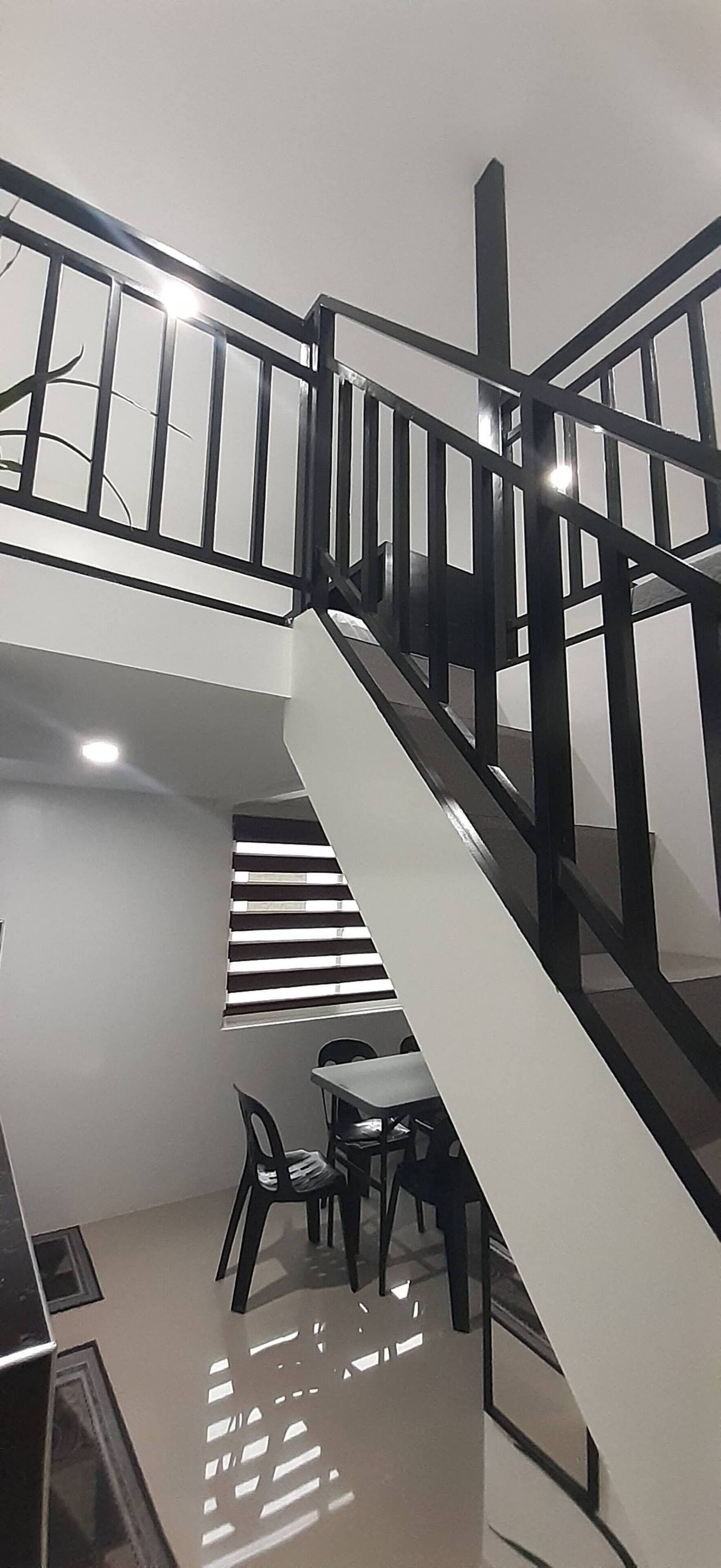 A staircase with a black railing leading to a lower level.