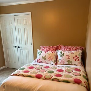 A bedroom with a bed, pillows, and a white door. - Southern Comfort with plenty of room for the entire family. (Byhalia)