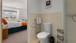 A hotel room with a bed, a toilet, and a shower area. - West Bridgford Luxury 2 bed 2 Bath Apartment (Nottingham)