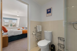Ein Hotelzimmer mit Bett, Toilette und Duschbereich.